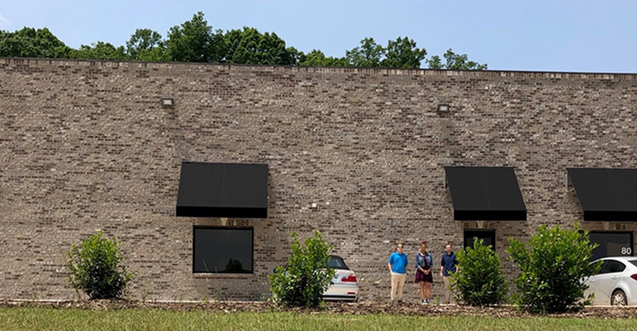 Archive photograph of a brick industrial building with staff outside