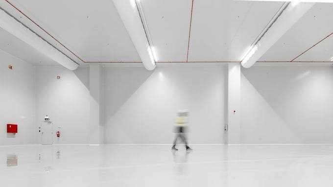 Grand hall de production blanc avec un opérateur qui traverse