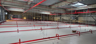 Large industrial hall under construction with sprinkler pipework overhead