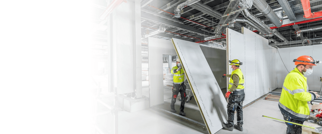 Ouvriers installant des panneaux isolants dans un bâtiment en construction