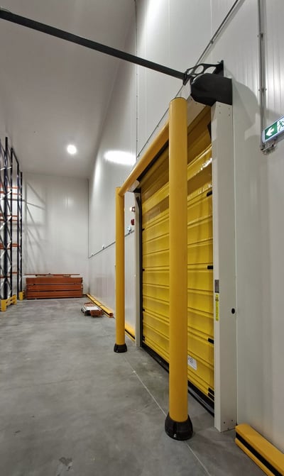 Cold store with a yellow high-speed roller door and protective bollards