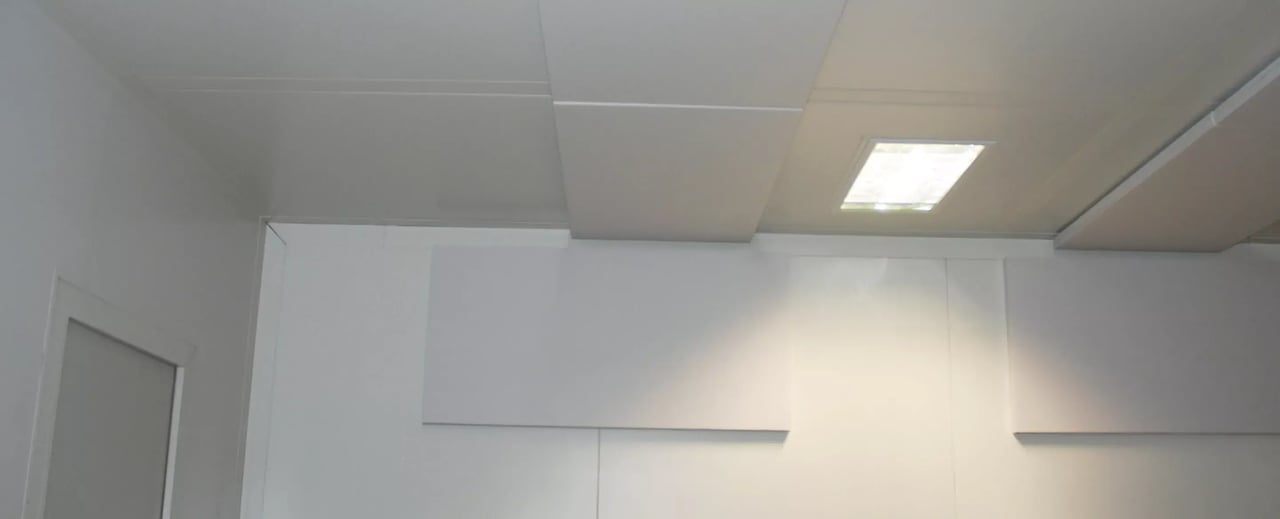 Jonction entre plafond et cloison de salle propre avec luminaire encastré